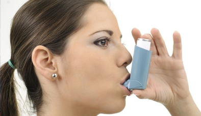 woman with asthma using inhaler