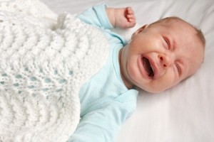 crying baby in crib suffering from colic