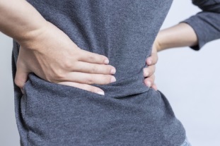 sciatica pain - woman holding lower back