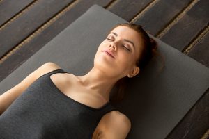 Young attractive woman lying in Dead Body exercise